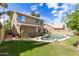 A home's backyard features a kidney-shaped pool with rock details, seating, and lush green grass at 1560 E Flint St, Chandler, AZ 85225