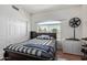 A cozy bedroom with a striped bed, a window, and a closet with white doors at 1560 E Flint St, Chandler, AZ 85225