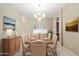 Bright dining room with a chandelier, large window, and a formal dining table with seating for six at 1560 E Flint St, Chandler, AZ 85225