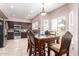 A well-lit dining room with dark wood table set and kitchen view with stainless steel appliances at 1560 E Flint St, Chandler, AZ 85225