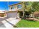 Charming two-story home features a lush front lawn, attached two car garage, and well-manicured landscaping at 1560 E Flint St, Chandler, AZ 85225
