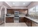 Beautiful kitchen with stainless steel appliances, mosaic backsplash, and rich wood cabinets at 1560 E Flint St, Chandler, AZ 85225