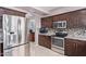 Well-equipped kitchen with stainless steel appliances, mosaic backsplash, and dark wood cabinetry at 1560 E Flint St, Chandler, AZ 85225