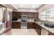 A well-lit kitchen showcases dark wood cabinets, stainless steel appliances, and stylish countertops, seamlessly blending style at 1560 E Flint St, Chandler, AZ 85225