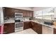 A well-lit kitchen showcases dark wood cabinets, stainless steel appliances, and stylish countertops, seamlessly blending style at 1560 E Flint St, Chandler, AZ 85225