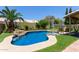 Beautiful in-ground pool with rock features, lush landscaping, and lounge area for relaxing outdoors at 1560 E Flint St, Chandler, AZ 85225