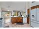Open kitchen showcases wood cabinets, granite counters, tile floors, and seamless flow to living area at 15774 W Indianola Dr # Six, Goodyear, AZ 85395