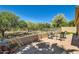 Scenic backyard with a stone patio, mature trees, and views of the surrounding landscape at 17323 E Teal Dr, Fountain Hills, AZ 85268