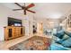 Spacious living room featuring stylish furniture, a ceiling fan, and a TV, perfect for relaxation and entertainment at 17323 E Teal Dr, Fountain Hills, AZ 85268