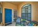 Cozy porch with comfortable seating, a vibrant blue door, and an arched window at 17323 E Teal Dr, Fountain Hills, AZ 85268