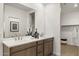 Bathroom featuring a double vanity with framed mirror and walk in closet with shelving and hanging rod at 17749 W Onyx Ave, Waddell, AZ 85355