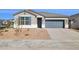 Charming single-story home featuring a xeriscaped front yard, gray stucco, and a two-car garage at 17749 W Onyx Ave, Waddell, AZ 85355