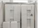 Shower featuring bright white subway tile, chrome hardware, and built in shelves at 17749 W Onyx Ave, Waddell, AZ 85355
