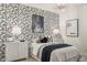 Bedroom featuring statement wallpaper, chandelier, and modern accents at 17755 W Onyx Ave, Waddell, AZ 85355