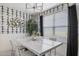 Bright dining room with a modern chandelier, white marble-topped table and designer wallpaper at 17755 W Onyx Ave, Waddell, AZ 85355