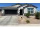 Charming single-story home featuring a neutral color scheme, a two-car garage, and a well-maintained, low-water, xeriscaped front yard at 17755 W Onyx Ave, Waddell, AZ 85355