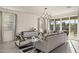 Comfortable living room with a large sofa, stylish accents, and abundant natural light from the sliding glass doors at 17755 W Onyx Ave, Waddell, AZ 85355