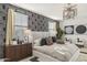 Stylish main bedroom with a modern accent wall, decorative lighting, and comfortable furnishings at 17755 W Onyx Ave, Waddell, AZ 85355