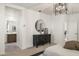 Well-lit main bedroom with stylish dresser, a decorative mirror, and modern design elements at 17755 W Onyx Ave, Waddell, AZ 85355