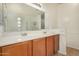 Bathroom with a double vanity, wood cabinets, and framed mirrors at 18475 N Madison Rd, Maricopa, AZ 85139