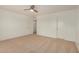 An airy bedroom offers neutral walls, carpeted floors, a ceiling fan, and closet space at 18475 N Madison Rd, Maricopa, AZ 85139