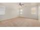 Spacious bedroom with neutral carpet, ceiling fan, and bright windows at 18475 N Madison Rd, Maricopa, AZ 85139