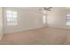Bright bedroom features neutral carpet, three windows, and ceiling fan at 18475 N Madison Rd, Maricopa, AZ 85139