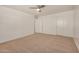 A bedroom features neutral walls, carpeted floors, closet space, and a ceiling fan at 18475 N Madison Rd, Maricopa, AZ 85139