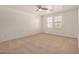 This bedroom offers neutral walls, carpeted floors, a ceiling fan, and natural light at 18475 N Madison Rd, Maricopa, AZ 85139