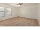 A bright bedroom offers neutral walls, carpeted floors, a ceiling fan, and natural light at 18475 N Madison Rd, Maricopa, AZ 85139