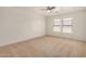 This bedroom offers neutral walls, carpeted floors, a ceiling fan, and natural light at 18475 N Madison Rd, Maricopa, AZ 85139