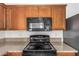 Close-up of the kitchen appliances featuring a stove and microwave at 18475 N Madison Rd, Maricopa, AZ 85139