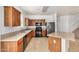 Spacious kitchen featuring a granite island, stainless steel refrigerator and wood cabinets at 18475 N Madison Rd, Maricopa, AZ 85139