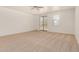 Spacious primary bedroom with plush carpeting, neutral walls, ceiling fan, and natural light at 18475 N Madison Rd, Maricopa, AZ 85139