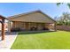 Landscaped backyard with artificial turf, covered patio, and a hot tub at 1926 S Longspur Ln, Gilbert, AZ 85295