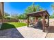 Relaxing outdoor space featuring a gazebo, stone pavers, artificial lawn, and mature landscaping at 1926 S Longspur Ln, Gilbert, AZ 85295