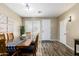 Dining room with wood-look tile floors, natural light, farmhouse-style table, and access to the front entry at 1926 S Longspur Ln, Gilbert, AZ 85295