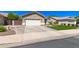 Exterior view of a single Gathering home with a two-car garage, artificial lawn, and desert landscaping at 1926 S Longspur Ln, Gilbert, AZ 85295