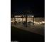 An outdoor gazebo illuminated by lights, featuring a full table and chair set for luxury outdoor living at 1926 S Longspur Ln, Gilbert, AZ 85295