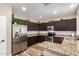 Charming kitchen featuring stainless steel appliances, granite countertops, and dark wood cabinets at 1926 S Longspur Ln, Gilbert, AZ 85295