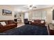 Comfortable living room featuring a ceiling fan, neutral paint, wood-look tile floors, and leather furniture at 1926 S Longspur Ln, Gilbert, AZ 85295