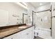 Well-lit bathroom features granite counters, white cabinetry, and a tiled shower and tub with glass doors at 19475 N Grayhawk Dr # 1128, Scottsdale, AZ 85255