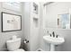 Charming half-bathroom with pedestal sink, decorative fixtures, and artistic wall accents at 19475 N Grayhawk Dr # 1128, Scottsdale, AZ 85255