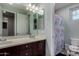 Bathroom featuring dual sinks with granite countertops, mirror, and shower with a patterned curtain at 21602 N 36Th St, Phoenix, AZ 85050