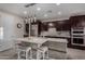 A modern kitchen showcases an island with seating, stainless steel appliances, pendant lighting, and tile backsplash at 21602 N 36Th St, Phoenix, AZ 85050