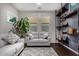 Cozy living room featuring a comfortable gray sofa, modern shelving, and a bright, airy atmosphere at 21602 N 36Th St, Phoenix, AZ 85050