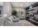 Comfortable living room featuring a gray sofa, dark wood floors, and stylish shelving for display and storage at 21602 N 36Th St, Phoenix, AZ 85050