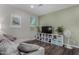 Well-lit living room with shelving, a gray sectional, dark wood flooring, and abundant natural light from a window at 21602 N 36Th St, Phoenix, AZ 85050