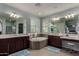 Luxurious main bathroom with dual vanities, a soaking tub, modern fixtures, and tile accents at 21602 N 36Th St, Phoenix, AZ 85050