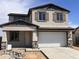 Charming two-story home featuring neutral stucco, decorative shutters, stone accents, and a two-car garage at 22368 W Monona Ln, Surprise, AZ 85387